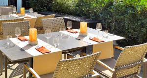 einen Tisch mit Stühlen und Weingläsern darauf in der Unterkunft Victor's Residenz-Hotel München in Unterschleißheim