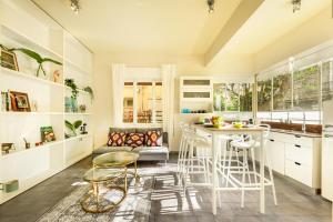 uma cozinha com bancos brancos e uma mesa num quarto em City Living at Tel Aviv's Famous Rothschild Boulevard by Sea N' Rent em Tel Aviv