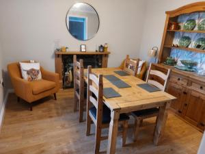 a dining room with a table and chairs and a mirror at southview in Portskerra