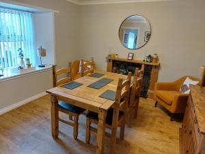 a dining room with a table and chairs and a mirror at southview in Portskerra +36 photos