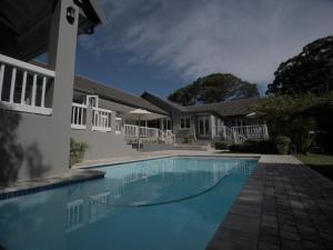 a swimming pool in front of a house at Arbour1 Guesthouse in George