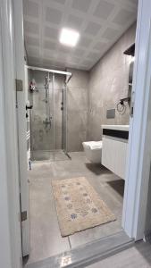 a bathroom with a shower and a toilet and a rug at HADRİANS TOWER in Antalya +55 photos