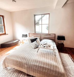 a bedroom with a large bed with a table on it at Farm hostel - The hause 1 in Elektrėnai