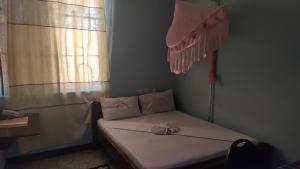 ein kleines Bett in einem Zimmer mit Fenster in der Unterkunft Dodoma Siesta Inn in Dodoma