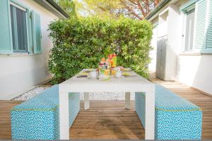 una mesa blanca con comida en el patio en ISA-Appartament Charme, 4 beds, air conditioning and private outdoor area in Village with 6 swimming-pools, only 1 km from the beach en Piombino