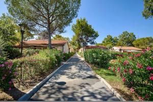 Una pasarela en un jardín con flores en ISA-Appartament Charme, 4 beds, air conditioning and private outdoor area in Village with 6 swimming-pools, only 1 km from the beach en Piombino