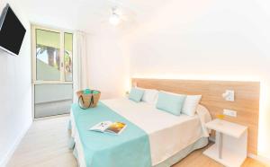 een kleine slaapkamer met een bed en een televisie bij Ona Alborada in Costa Del Silencio