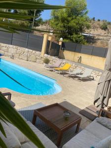 a swimming pool with chairs and a table next to it at Bas de Villa détente in Carros