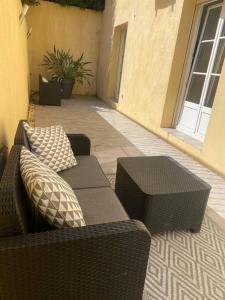 a patio with a couch and two pillows on it at Bas de Villa détente in Carros