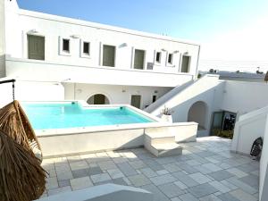 a swimming pool in front of a white building at Artemis Hotel in Antiparos Town