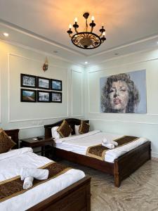 a bedroom with two beds and a painting on the wall at Ma Pi Leng Hotel in Dồng Văn