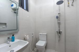a bathroom with a shower and a toilet and a sink at JOY B Apartment 2 in Kiembi Samaki