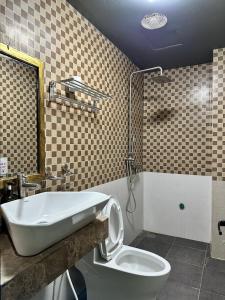 a bathroom with a tub and a toilet and a sink at Ma Pi Leng Hotel in Dồng Văn