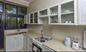a kitchen with white cabinets and a stove top oven at JOY B Apartment 2 in Kiembi Samaki