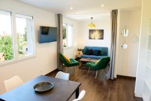 a living room with a blue couch and green chairs at Le Forez 