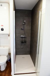 La salle de bains est pourvue d'une douche avec une porte en verre. dans l'établissement Le Forez, 