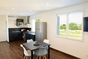 a kitchen and dining room with a table and chairs at Le Forez Appartement 4 pers ou Studio 2 pers in Cuzieu