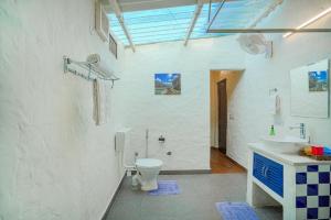 a white bathroom with a toilet and a sink at SaffronStays Dalewal Jungle Lodge, Hoshiarpur in Hoshiārpur +45 photos
