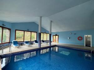una gran piscina con paredes azules y sillas azules en Wuau! Hotel Segle XX, en El Tarter