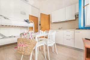 cocina y comedor con mesa y sillas en ISA-Appartament plus 4 beds, air conditioning and private outdoor area in Village with 6 swimming-pools en Piombino