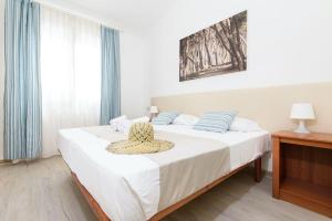 a bedroom with a bed with a hat on it at ISA-Appartament plus 4 beds, air conditioning and private outdoor area in Village with 6 swimming-pools in Piombino