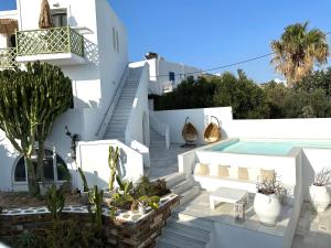 a white villa with a swimming pool and stairs at Artemis Hotel in Antiparos Town