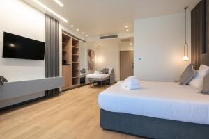 a hotel room with a bed and a tv at GRAND PATELLI in Myrina