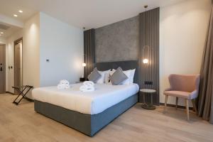 a bedroom with a large bed and a chair at GRAND PATELLI in Myrina