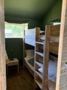 2 Etagenbetten in einem Zimmer mit Fenster in der Unterkunft Safari tent lodges with a beautiful view at Lot Sous Toile 