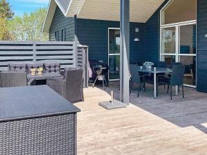 eine Terrasse mit einem Tisch und Stühlen auf einem Haus in der Unterkunft 6 person holiday home in L gst r in Løgsted