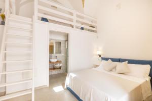 Habitación blanca con cama y escalera en Dimora Ferente, en Salve