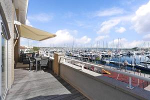 a balcony with a view of a marina with boats at Appartement in Zeeland - Kabbelaarsbank 512 - Port Marina Zélande - Ouddorp - With garage - not for companies in Ouddorp