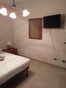 Un dormitorio con una cama y un televisor en la pared. en Cà di Gat, en La Morra 20 fotos más