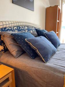 ein Bett mit blauen Kissen darüber in der Unterkunft Apartamento con vistas Sada (saudade) in Sada