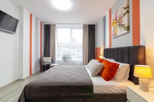 a bedroom with a large bed with orange pillows at Royal 2 apartments on Shevchenka str in Lviv