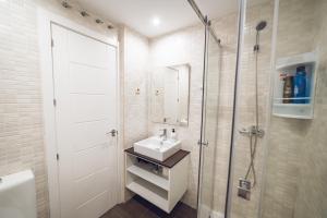 a white bathroom with a sink and a shower at VISTALEGRE Apartments in Madrid