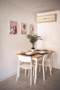 マドリードにあるVISTALEGRE Apartmentsのダイニングルーム(植物付きのテーブルと椅子付)