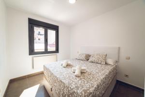 VISTALEGRE Apartments في مدريد: غرفة نوم بسرير وملاءات بيضاء ونافذة