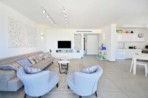 a living room with a couch and chairs and a kitchen at Granite 2BR by HolyGuest in Tel Aviv
