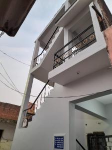 a white building with stairs on the side of it at Double Bedroom in Homestay in Gorakhpur