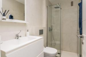 a bathroom with a toilet and a sink and a shower at TORREÓN FRENTE AL MAR in Adeje +12 photos