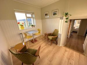 a living room with chairs and a table and a window at Modern and spacious Holiday Home with Hot Tub in Snæfellsbær
