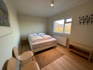 a small bedroom with a bed and a window at Modern and spacious Holiday Home with Hot Tub in Snæfellsbær