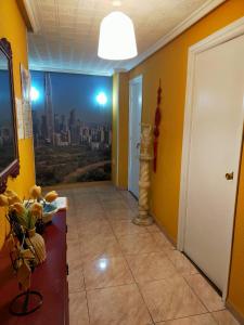 阿斯托加的住宿－Apartamento Shenzhen en Astorga Camino de Santiago Cochera bicis，黄色墙壁和城市画的走廊