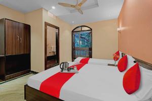 - une chambre avec un grand lit blanc et des oreillers rouges dans l'établissement Oceana The Holiday Home Near Immaculate Conception Church, à Panaji