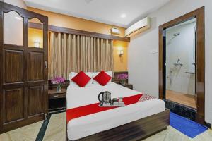 ein Schlafzimmer mit einem Bett mit roten Kissen und einer Dusche in der Unterkunft Oceana The Holiday Home Near Immaculate Conception Church in Panaji