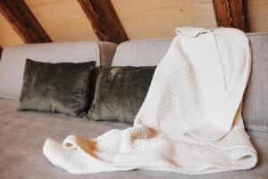 a white blanket on a couch with two pillows at Ansitz Layshof Apartment Turm in Merano