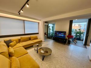 a living room with a yellow couch and a flat screen tv at Top Artistic Luxury Apartment in Limassol