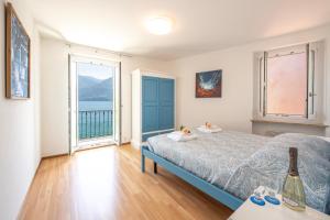 um quarto com uma cama e uma grande janela em Casa al Lago Apartments - Brissago Experience em Brissago