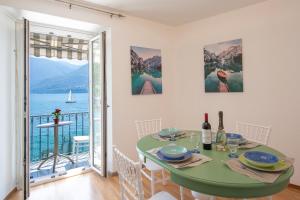 ein Esszimmer mit einem Tisch und Meerblick in der Unterkunft Casa al Lago Apartments - Brissago Experience in Brissago